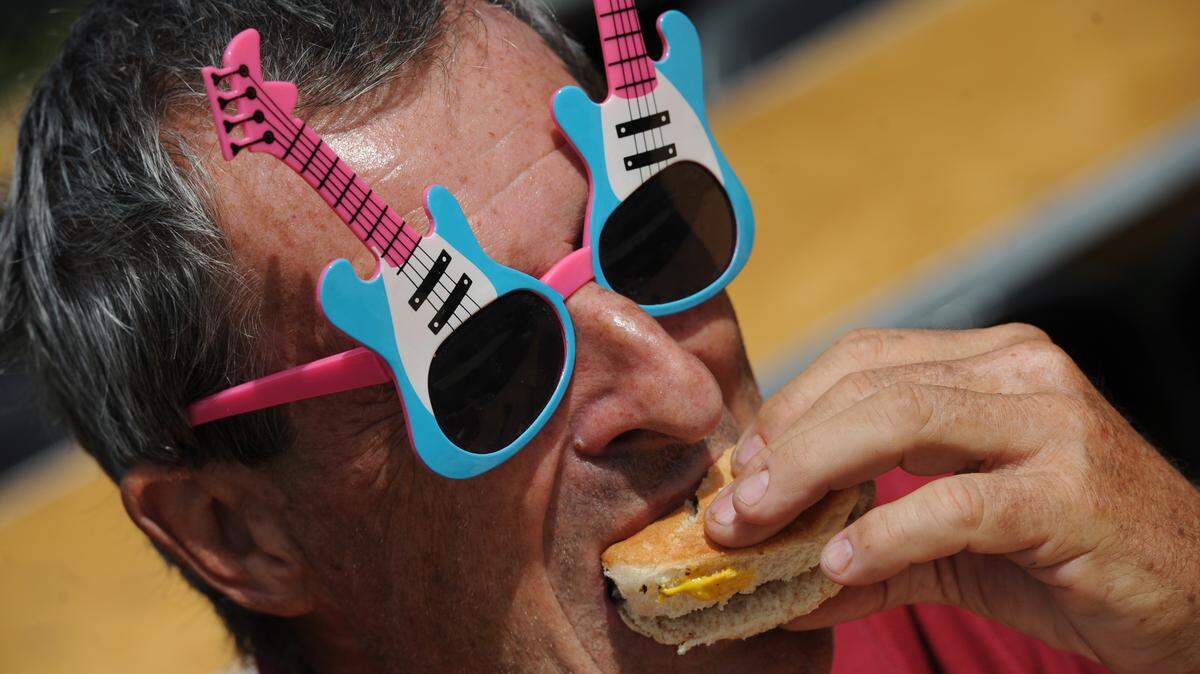 Rich Zang bites down on a hamburger slider during the 29th annual Taste of Manatee event Saturday at Sutton Park in Palmetto.GRANT JEFFERIES/Bradenton Herald