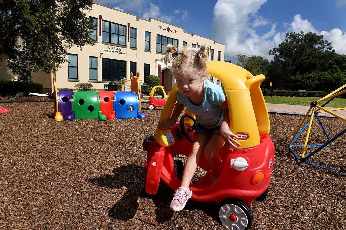 07/30/21—Farrah Fail, 3, plays on a temporary playground during the ribbon-cutting ceremony for the Forza Child Development Center at the Parrish Schoolhouse.