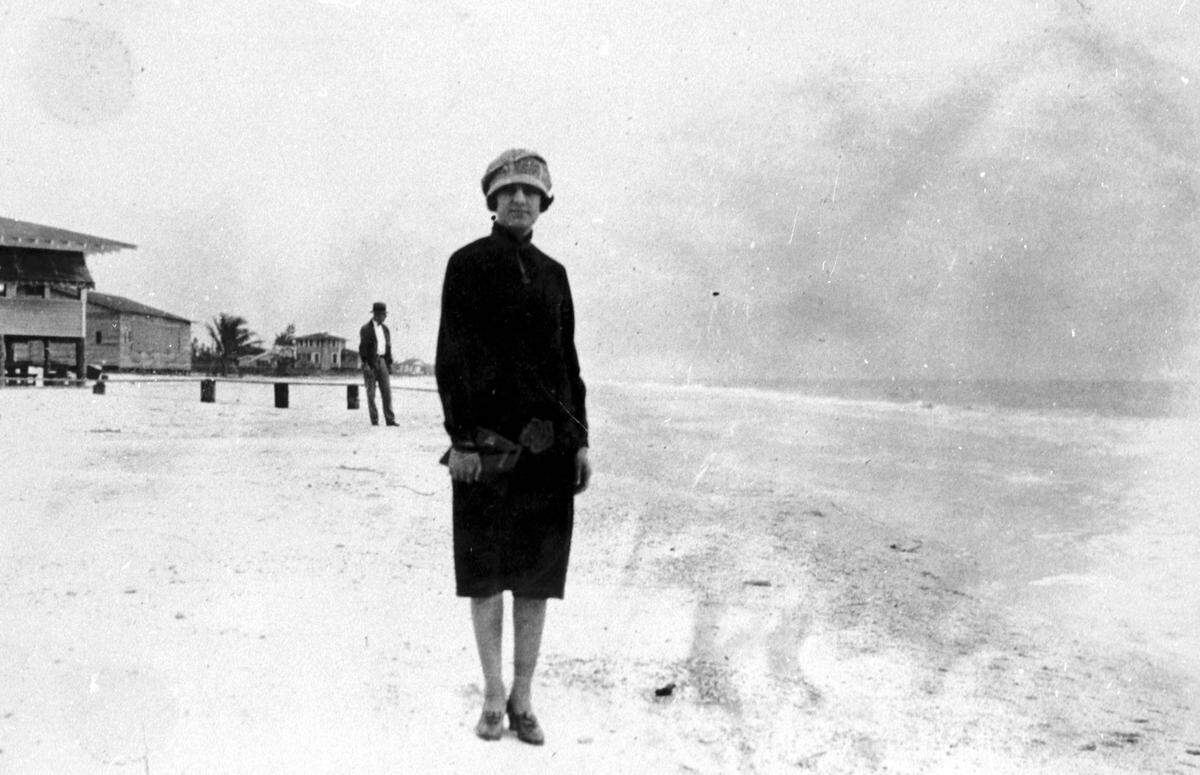 A lady on the beach near the Bradenton Beach bathhouse. Other wooden homes are visible along the Gulf of Mexico in the background in the 1920s