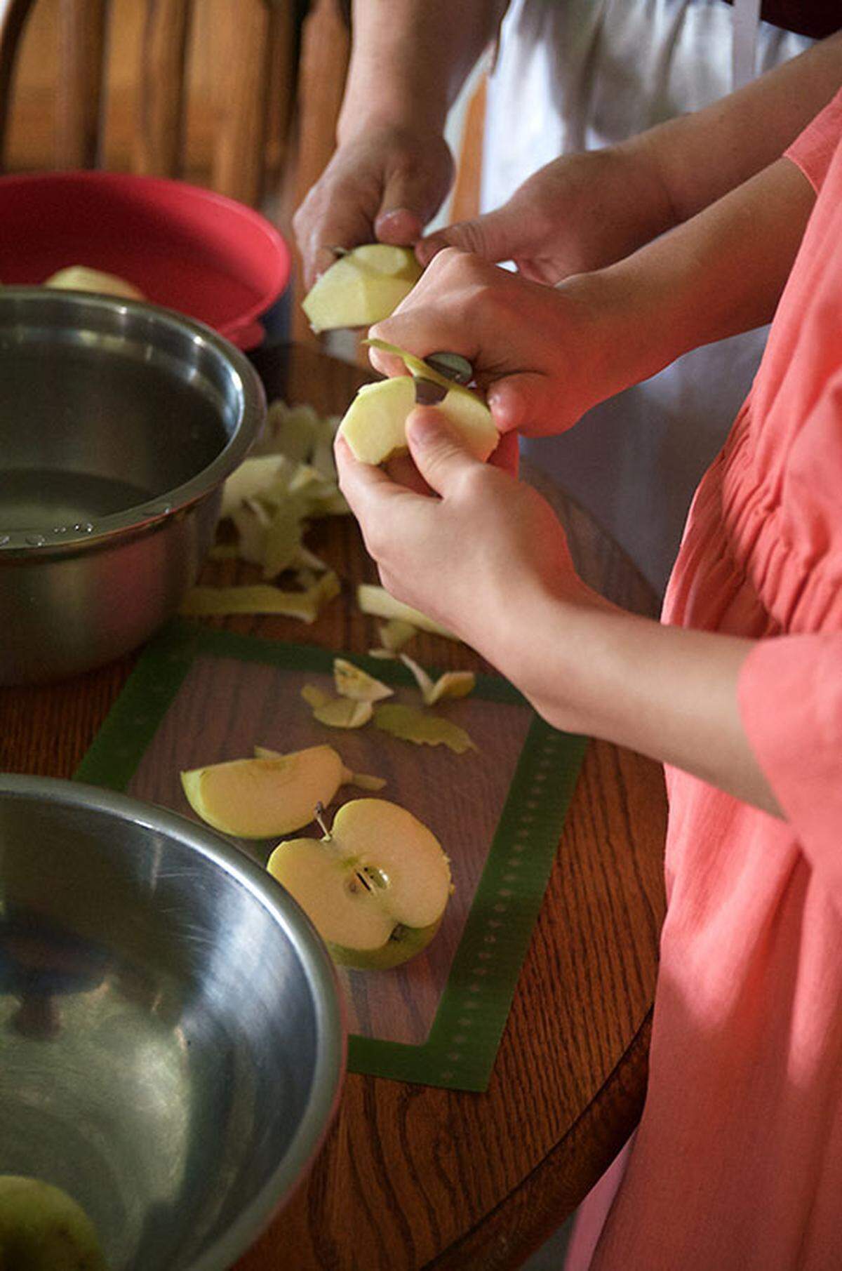 It takes many hands to schnitz — peel, core and slice — enough apples for apple butter. Apples, cider and sugar are traditionally cooked in a kettle over a fire for many hours until the mixture is reduced to a thick, creamy consistency.