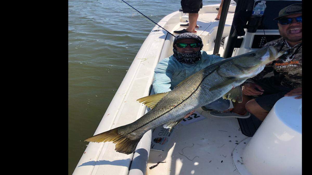 Members of Richardson Stinton Roofing fishing team show off a 44-inch snook they caught during the recent Fire Charity Fishing Tournament.