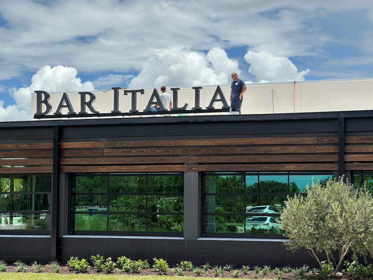Workers put the finishing touches on the Bar Italia rooftop sign at Lakewood Ranch. The restaurant has an estimated July 15 opening date.