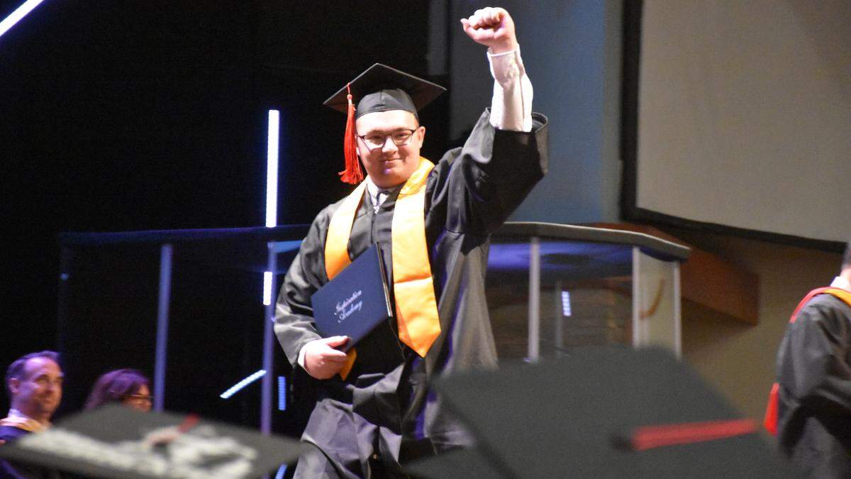 Inspiration Academy graduate Josiah S. Fitzsimmons fists pumps as he walks across the stage Saturday afternoon with his high school diploma during the 2019 graduation ceremony.