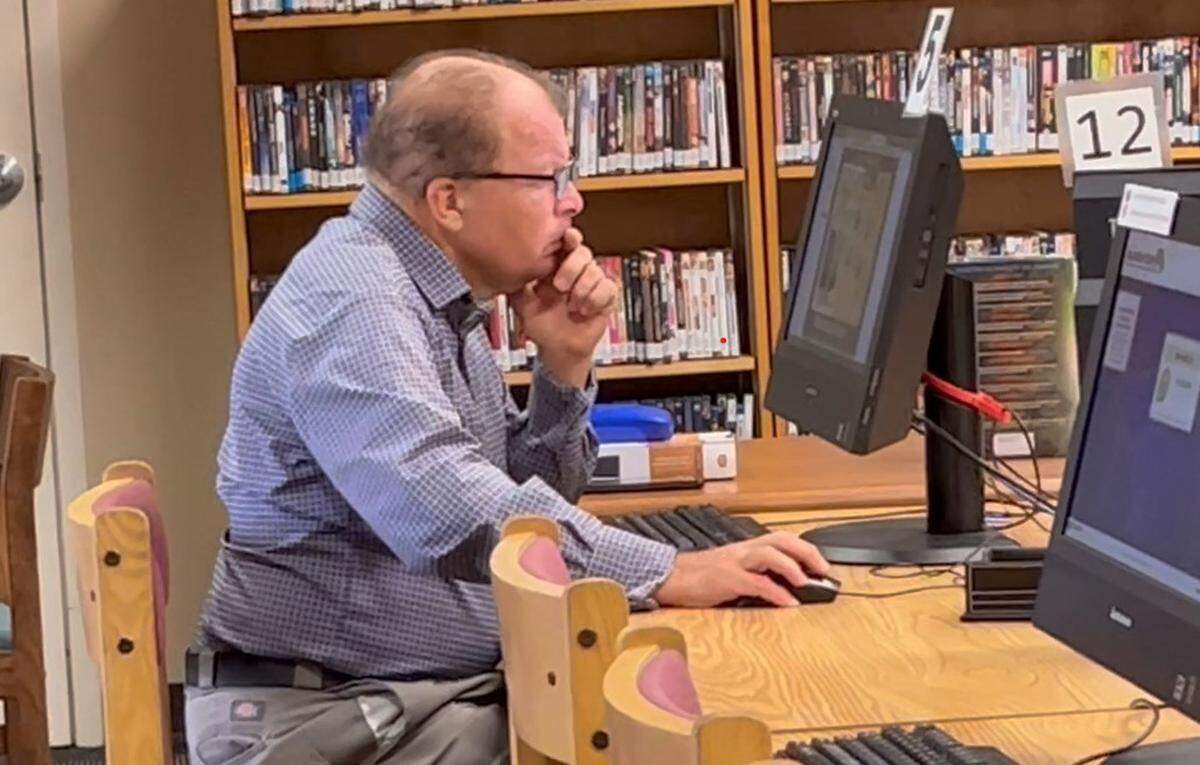 A man works at a computer inside the DeSoto County Library. The library’s access to the internet is a lifeline to many county residents.