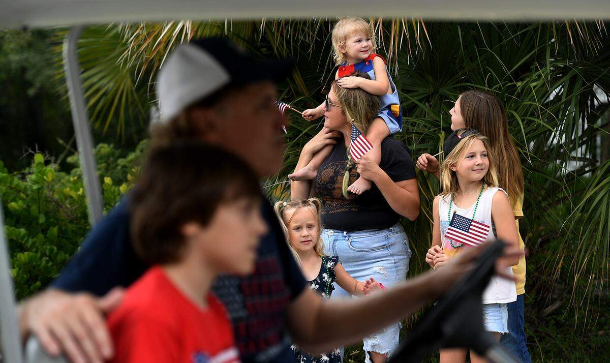 11/11/21—A family watches from the sidewalk as golf carts and floats pass by in the City of Anna Maria’s Old Soldiers and Sailors Veterans Day Parade.