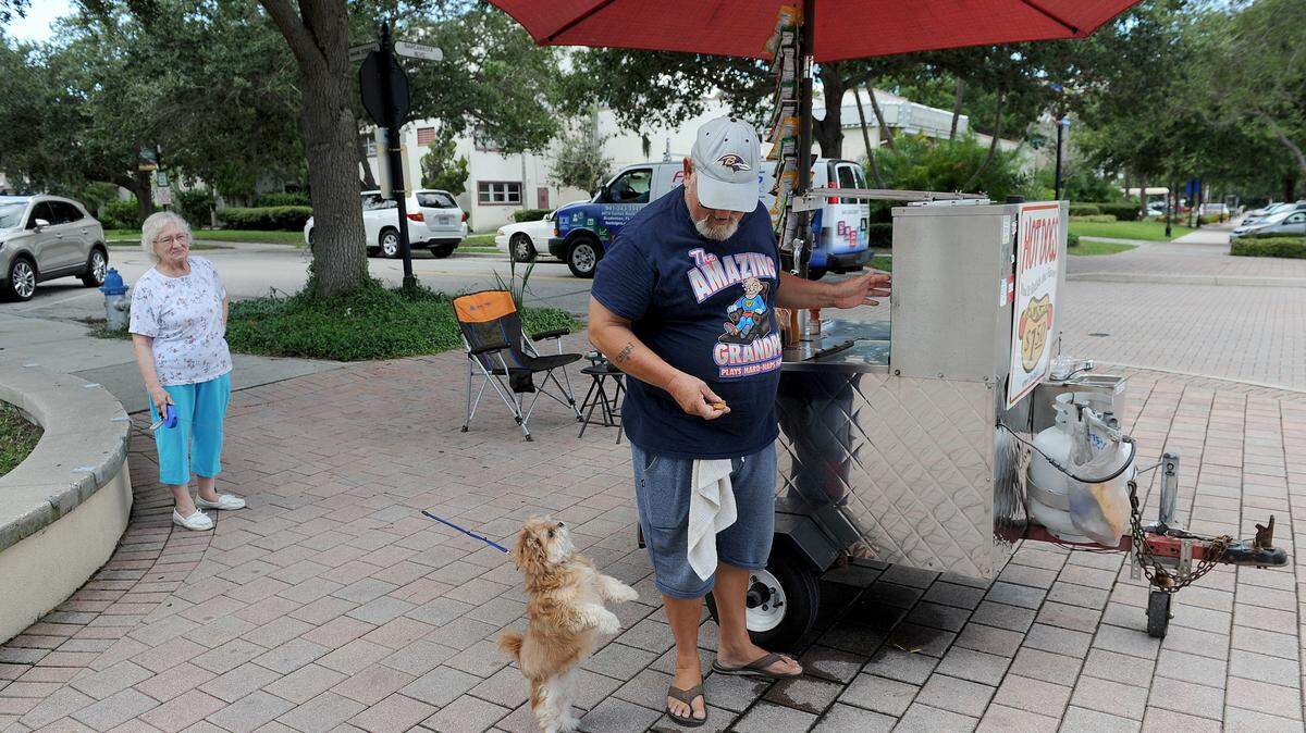 Doug Menser, owner of the Dougout hot dog stand, set up on the corner of Old Main Street and Barcarrota Avenue, has a special customer, Chewie, and his owner Peg Bell. Chewie is one of many dogs that seek out Menser, who makes a point of keeping doggie treats handy.