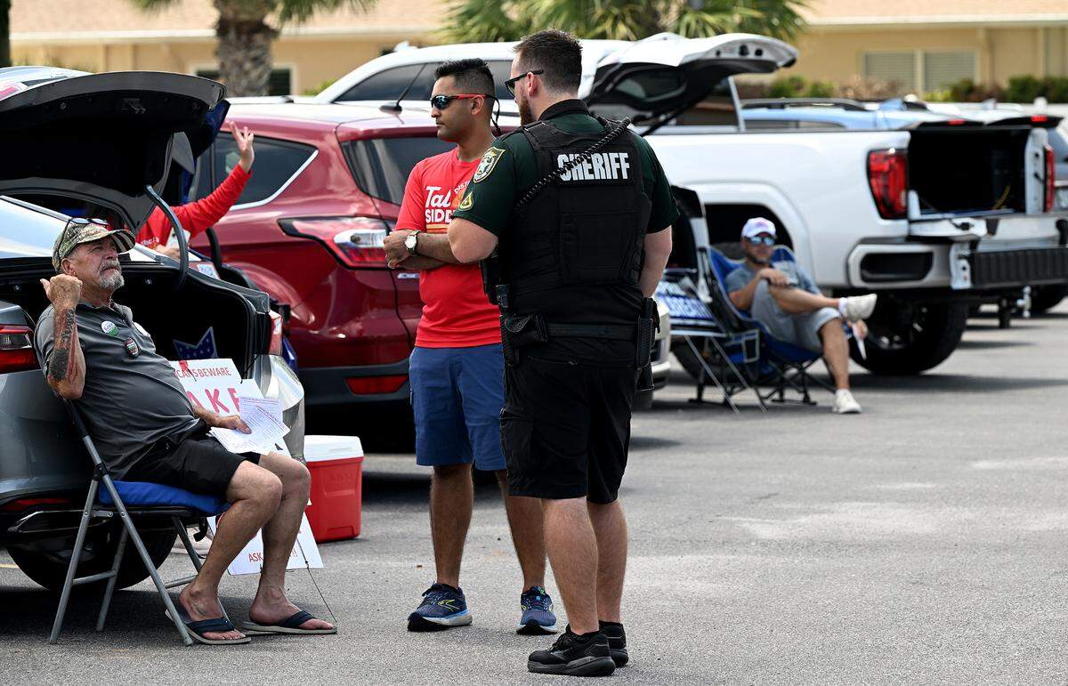 Tal Siddique, red shirt speaks with a Manatee County Deputy after a verbal incident in the parking lot of the Elks Lodge #1511, which is Precinct 323.