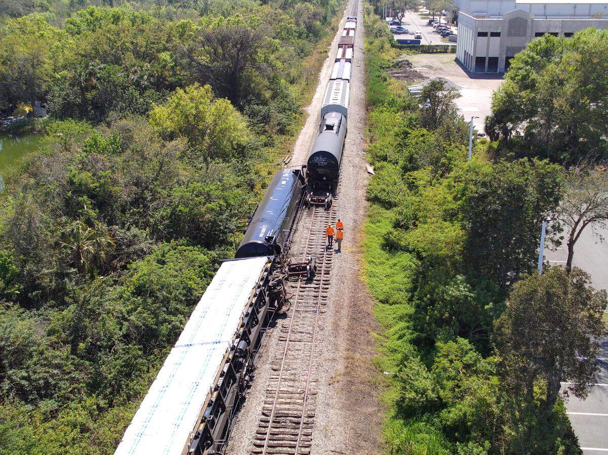 Workers inspect a Seminole Gulf Railways train that derailed in Bradenton Feb. 28, 2023.