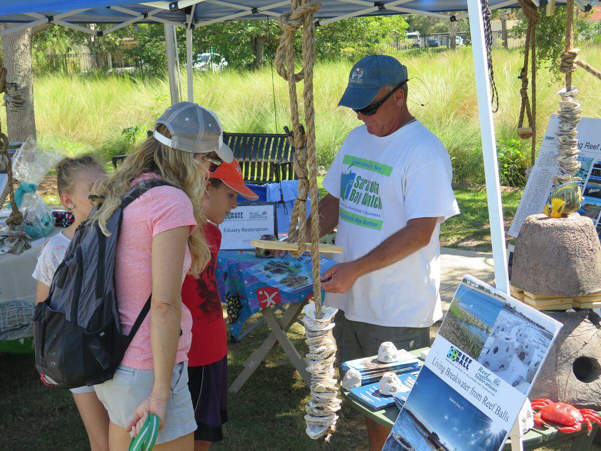 During a visit to Saturday afternoon’s Shoreline Shindig along the Bradenton Riverwalk, Tracy Topjun and her two children, Selby and Bodhy, learn about reef balls, which are used to attract and develop coral reefs.