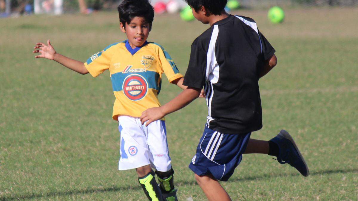 Miguel Reyes, 12, and Landon Reyes, 6, converge on a soccer ball during a family outing on Friday at Braden River Park.JAMES A. JONES JR./Bradenton Herald