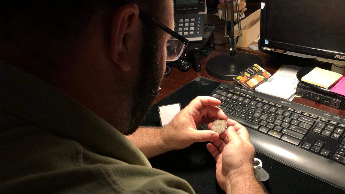 6/3/2021--A grader at Certified Collectibles Group evaluates a coin. The company plans to add 100 employees by the end of summer, bringing its Lakewood Ranch workforce to 500. &nbsp;To hit this target, CCG is offering a $2,500 sign-on bonus for new employees who start by Sept. 30. 