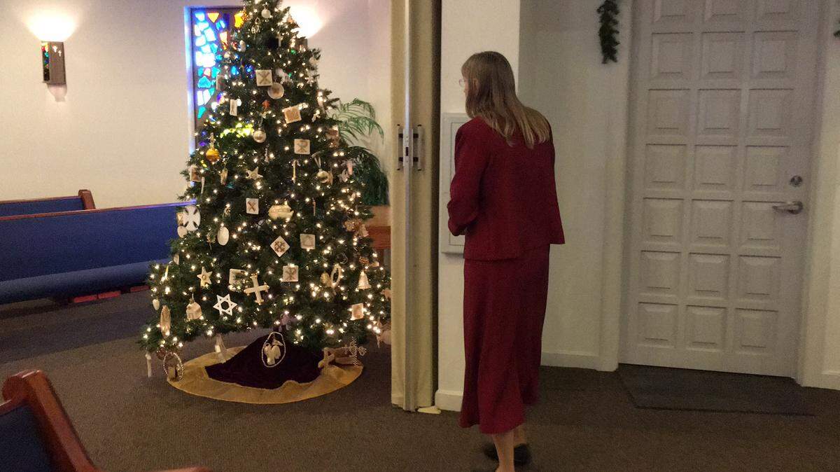 The Rev. Sharon Davis of Manatee United Methodist Church, 315 15th St. E., Bradenton, admires a special tree honoring Jesus Christ erected by church members in the sanctuary before Sunday's service. 
 RICHARD DYMOND/Bradenton Herald