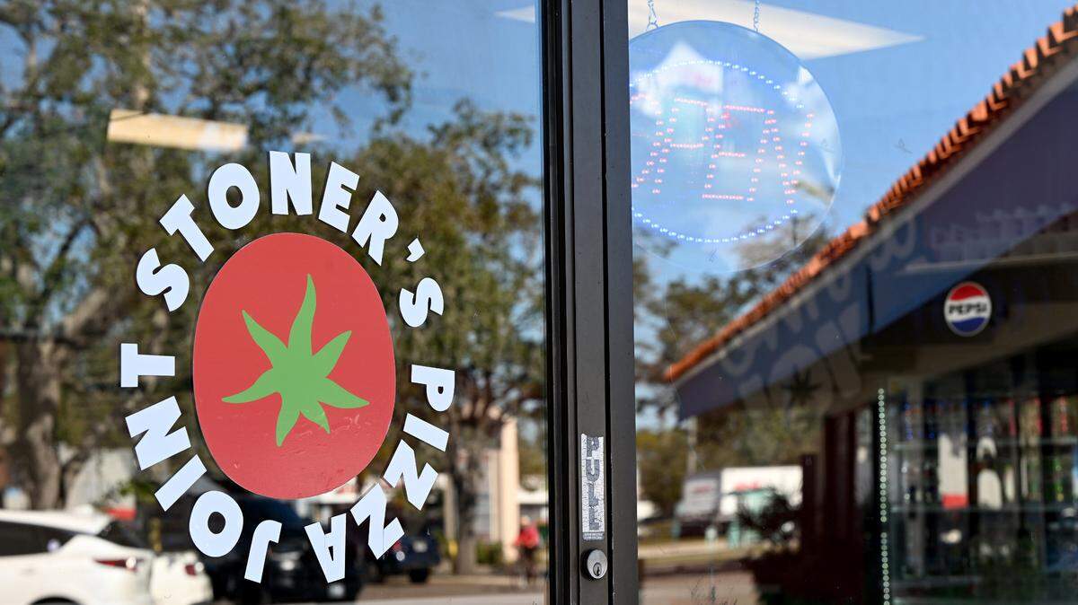 The parking area outside the newly-opened Stoner’s Pizza Joint is reflected in the window at 3985 Cortez Road West in Bradenton.