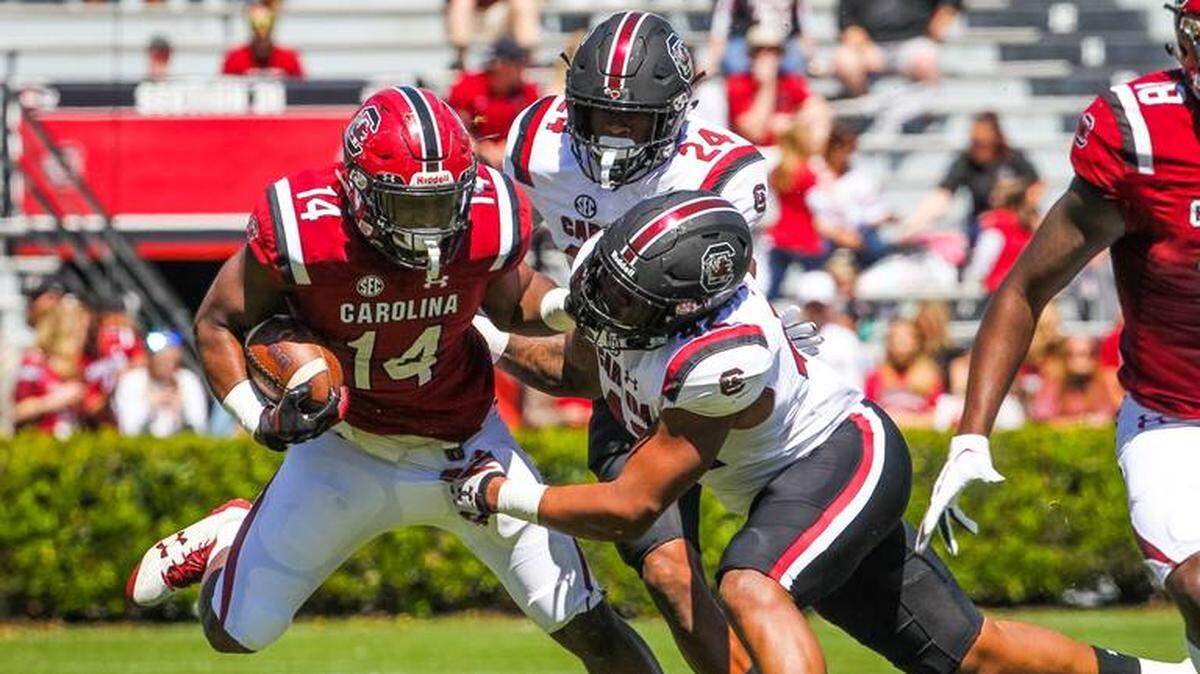 South Carolina running back Deshaun Fenwick, a Braden River High graduate, tries to elude linebacker Rosendo Louis (42) and defensive back Israel Mukuamu (24) during the Garnet and Black spring game at Williams-Brice Stadium in Columbia, S.C., on Saturday.