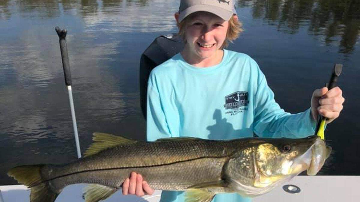 Ethan Kutcher, 11, of Minnesota shows off a 35-inch snook caught with Capt. Jeremy Rzonca.