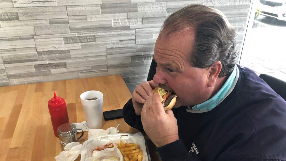 First-time customer Wayne Batten tries a hamburger at R Burgers N’ Wings, 4266 53rd Ave. E., Bradenton.