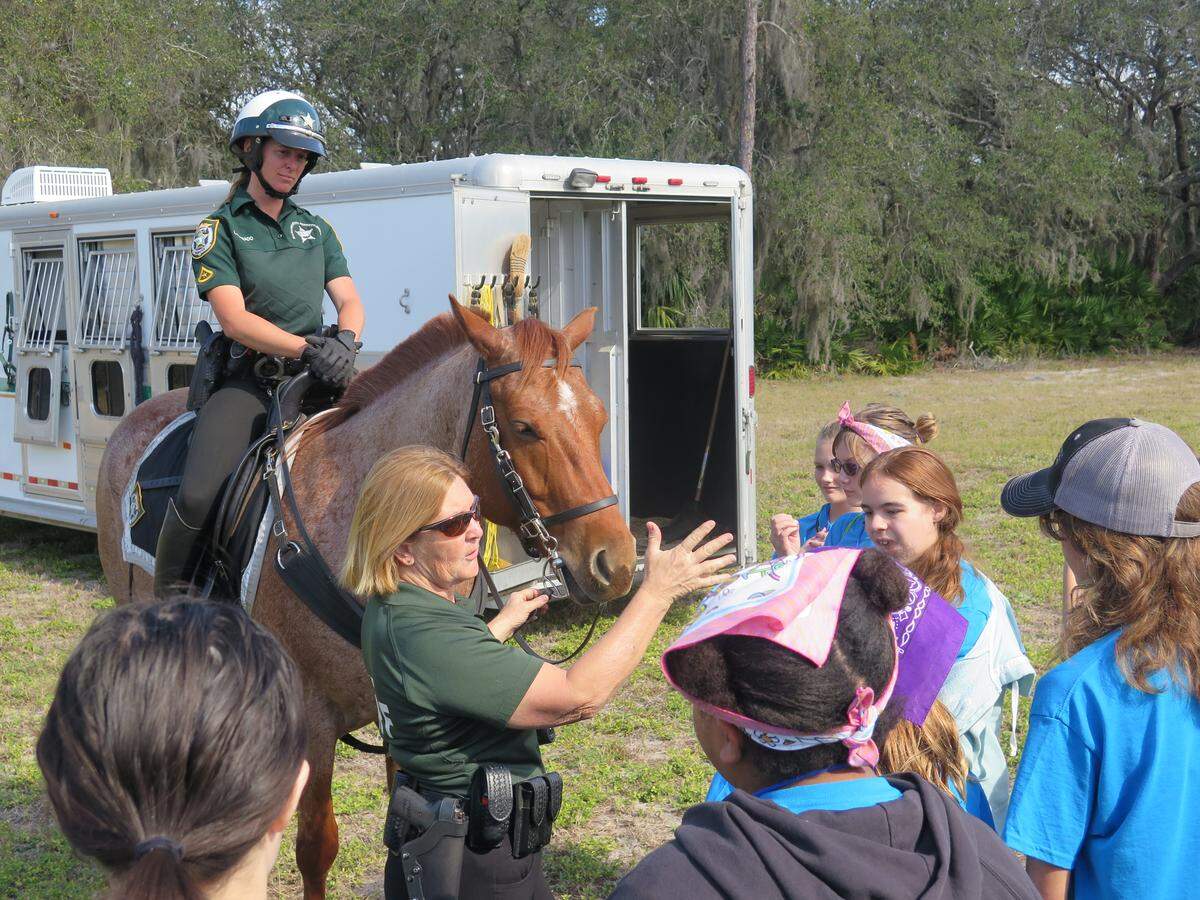 Deputy Holly Combee (middle) explains how the Manatee County Sheriff’s Office uses horses and mounted patrol to keep communities safe.