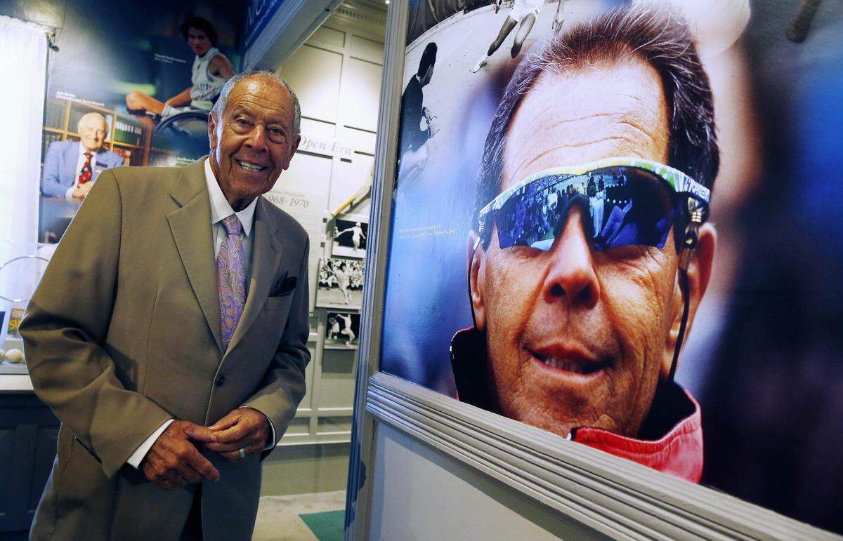 Nick Bollettieri, founder of IMG Academy, pauses in the tennis museum beside a photograph of himself from 1991 before being inducted into the Tennis Hall of Fame in Newport, R.I., Saturday, July 12, 2014.