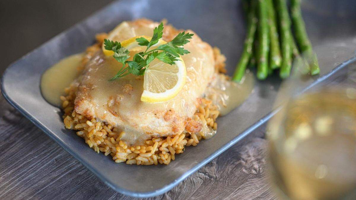 Sauteed tripletail served with citrus cream sauce and yellow rice is one of the dinner entrees featured at Tripletail Seafood & Spirits for Savor Sarasota’s Restaurant Week, June 1-14, 2023.
