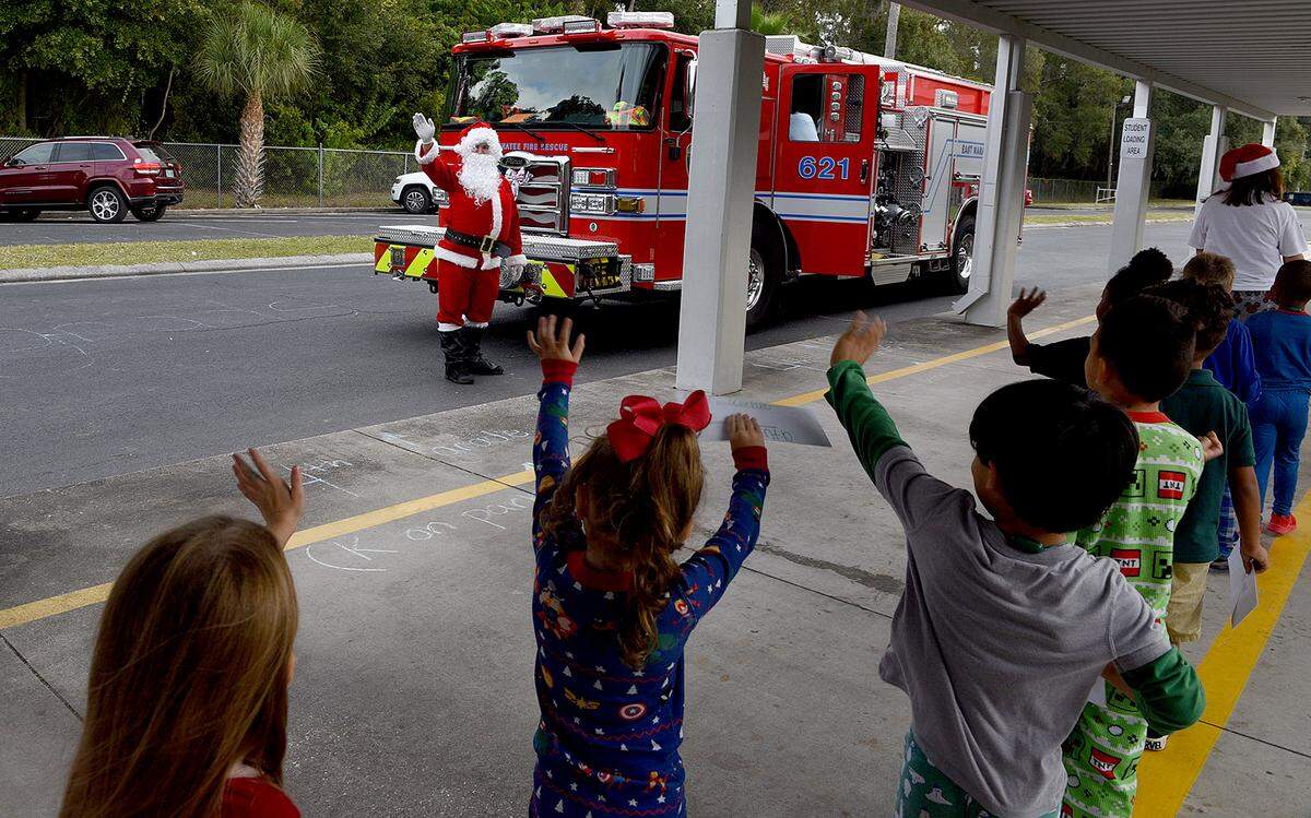 12/20/21—Children wave as Santa arrives on an East Manatee Fire Rescue truck to delight of pre-kindergarteners and ESE students at Bashaw Elementary School.