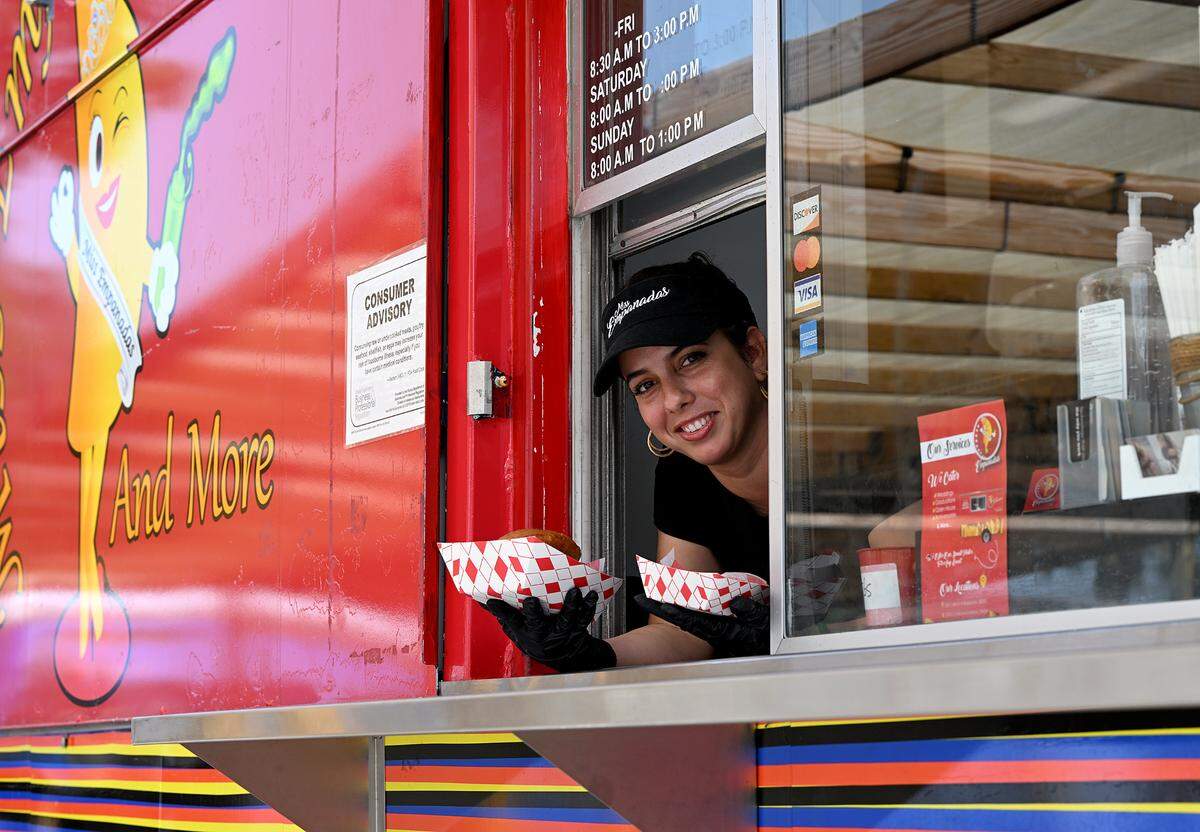 Claudia Risandra Padrón serves up empanadas at the Miss Empanada food truck behind the former Miller’s Dutch Kitchen on 14th Street on Tuesday, Oct. 3, 2023.