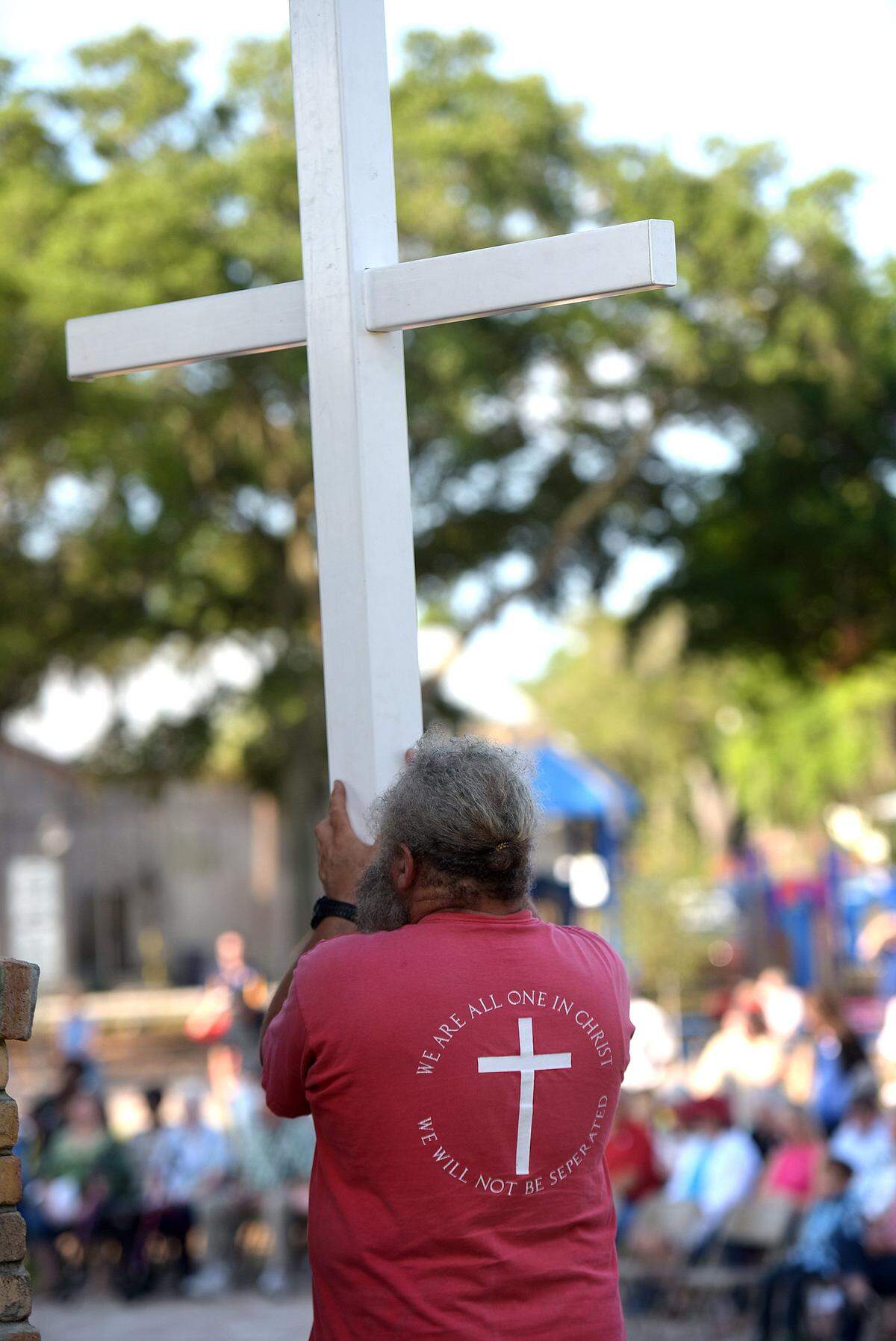 Michael Lombardi holds a large cross at Sutton Park in Palmetto in observance of the 2017 National Day of Prayer. A national atheist group called Freedom from Religion Foundation wants the city of Palmetto to stop being involved in the annual event.