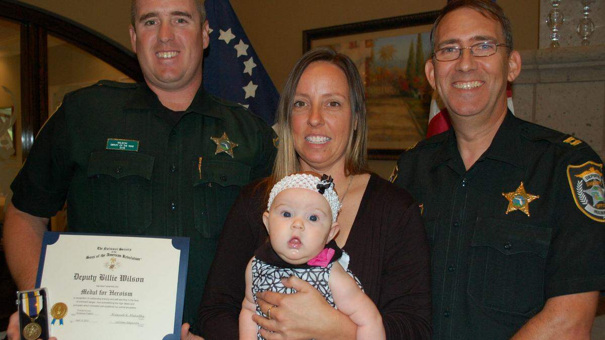 Deputy Billie Wilson, his wife Christina Wilson, and their 15- week old daughter Faith are shown with Captain Ian Kogel of the Manatee County Sheriff's Office. 
 PROVIDED PHOTO