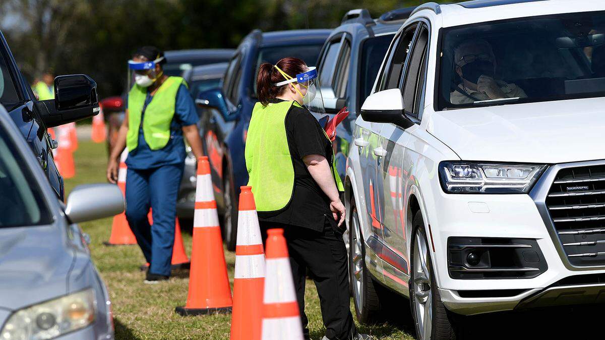 03/08/21--Health care professionals vaccinate people as they drive through a line at the Manatee County Public Safety Center in Bradenton at 2101 47th Terrace E. For four weeks the site will administer first doses of the vaccine for COVID-19, and the second four weeks will be for second doses. The vaccination site will be augmented with workers from the state, and will be administer 900-1000 doses a day, said Steve Litschauer, Chief of Emergency Management.