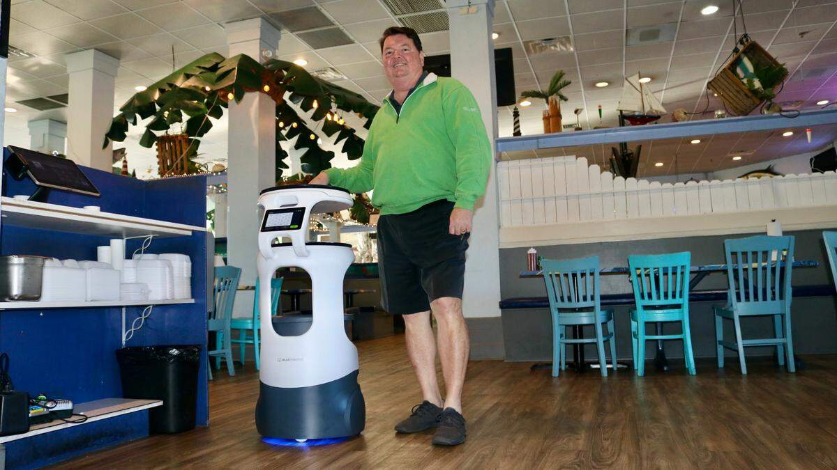 For several months, restaurateur John Horne, shown above on 2/9/2022, has been using a robot named “Pearl” to deliver food to the tables at the Anna Maria Oyster Bar Landside at 6906 14th St. W., Bradenton.