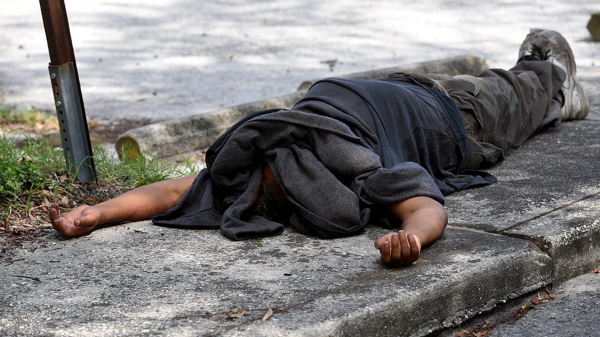 The City of Bradenton approved emergency funding to fence off the parking lot behind 7-11 at the intersection of 9th and 14th Street West. A man sleeps on the sidewalk just next to the area to be fenced.