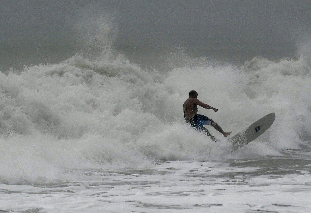 11/11/20--Surfers revel in the strong waves caused by the approach of Tropical Storm Eta on Cortez Beach.