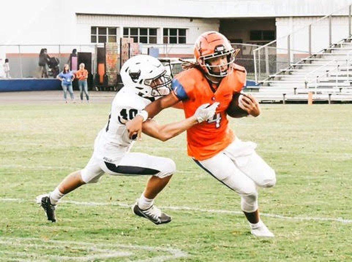 Parrish Community senior linebacker James Keen (left) attempt a tackle. He had never played or watched football before joining the new Bulls program four years ago.