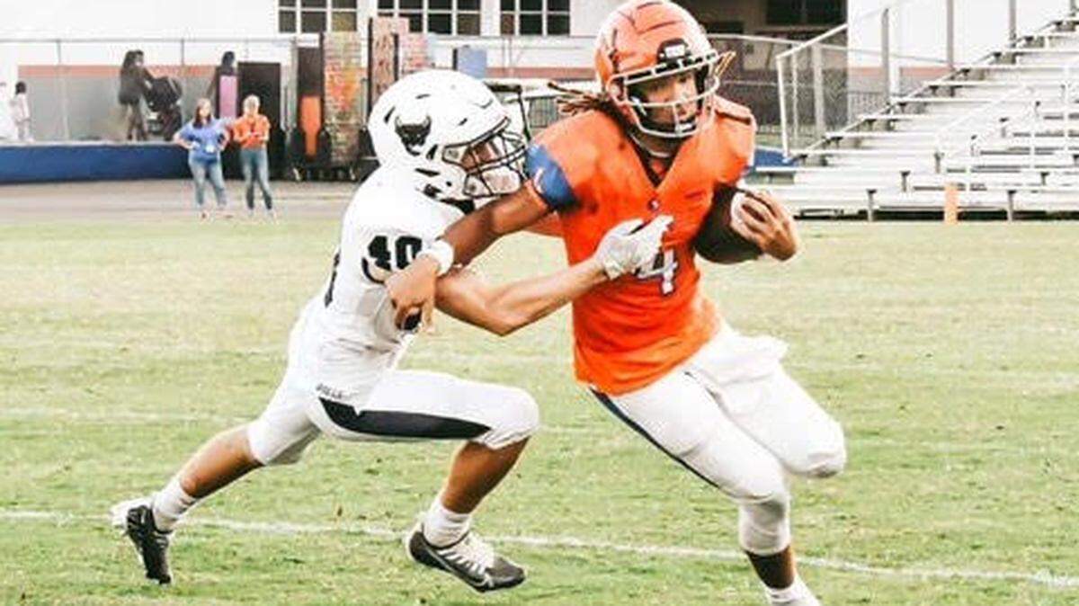 Parrish Community senior linebacker James Keen (left) attempt a tackle. He had never played or watched football before joining the new Bulls program four years ago.