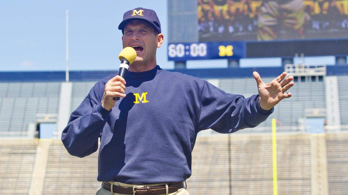 Michigan head coach Jim Harbaugh introduces his team to fans and media at Michigan Stadium, during the NCAA college football team's annual media day in Ann Arbor, Mich., Thursday, Aug. 6, 2015. (AP Photo/Tony Ding)