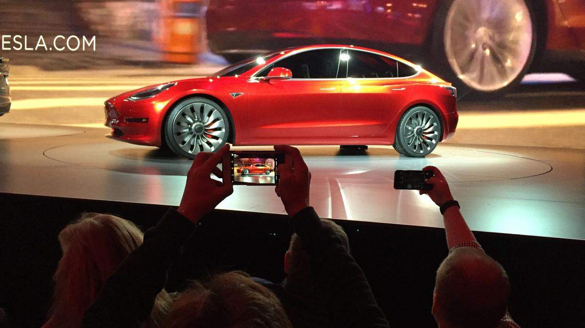 Tesla Motors unveils the new lower-priced Model 3 sedan at the Tesla Motors design studio in Hawthorne, Calif., Thursday, March 31, 2016. It doesn't go on sale until late 2017, but in the first 24 hours that order banks were open, Tesla said it had more than 115,000 reservations. Long lines at Tesla stores, reminiscent of the crowds at Apple stores for early models of the iPhone, were reported from Hong Kong to Austin, Texas, to Washington, D.C. Buyers put down a $1,000 deposit to reserve the car. (AP Photo/Justin Prichard)