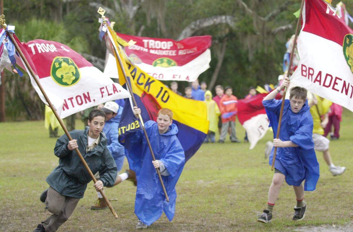 Scouts run with their troop flags, showing their colors and pride before the opening ceremonies of the 2001 Manatee District Camporee, as over five hundred scouts from Manatee County gather at Camp Flying Eagle for the weekend.