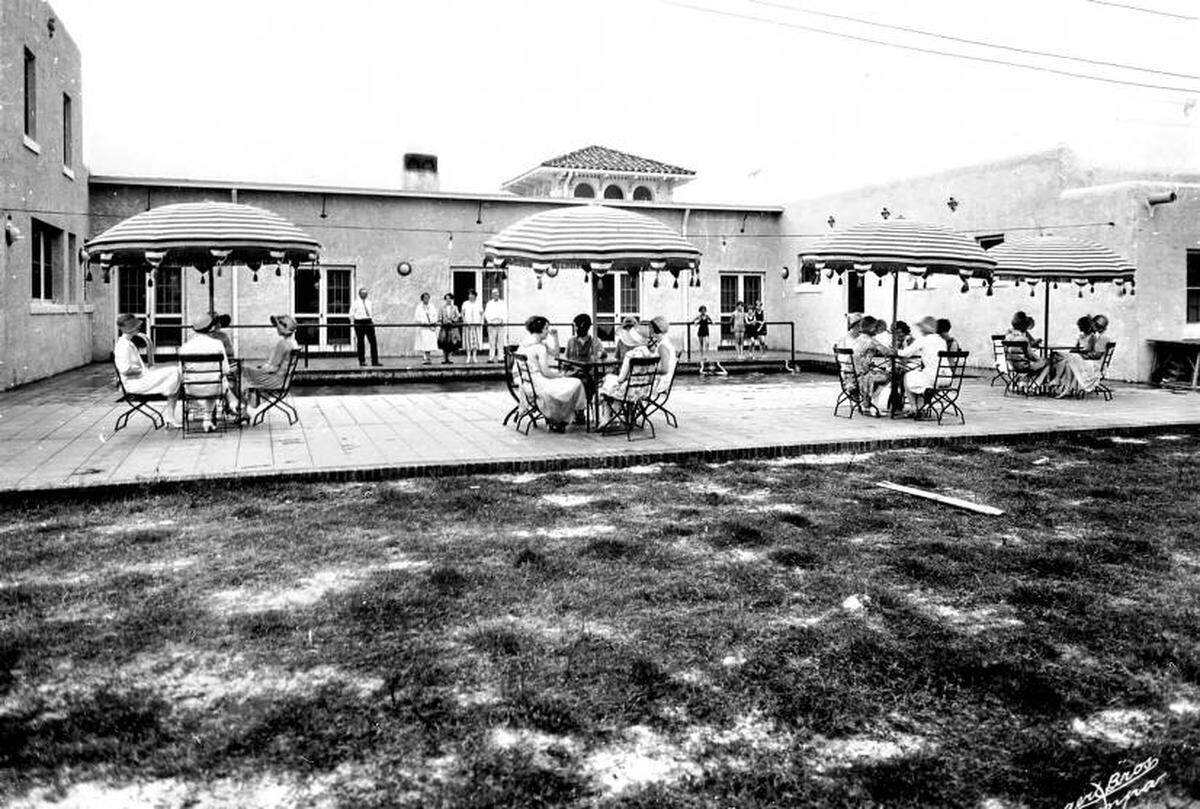 Exterior of the Bradenton Country Club in the 1920s, where adults and children utilize the pool and terrace.