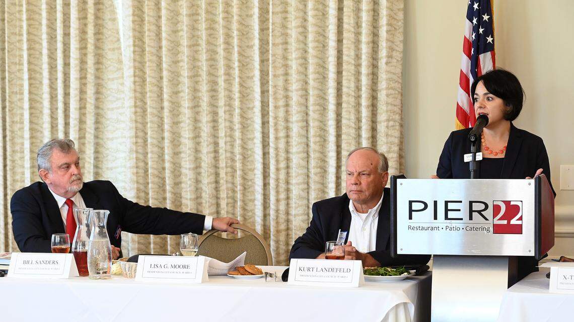 Lisa Gonzalez Moore speaks at the podium during a debate hosted by the Manatee Tiger Bay Club on Sept. 22, 2022. She is running against incumbent Councilman Bill Sanders (left) and fellow challenger Kurt Landefeld (center.)