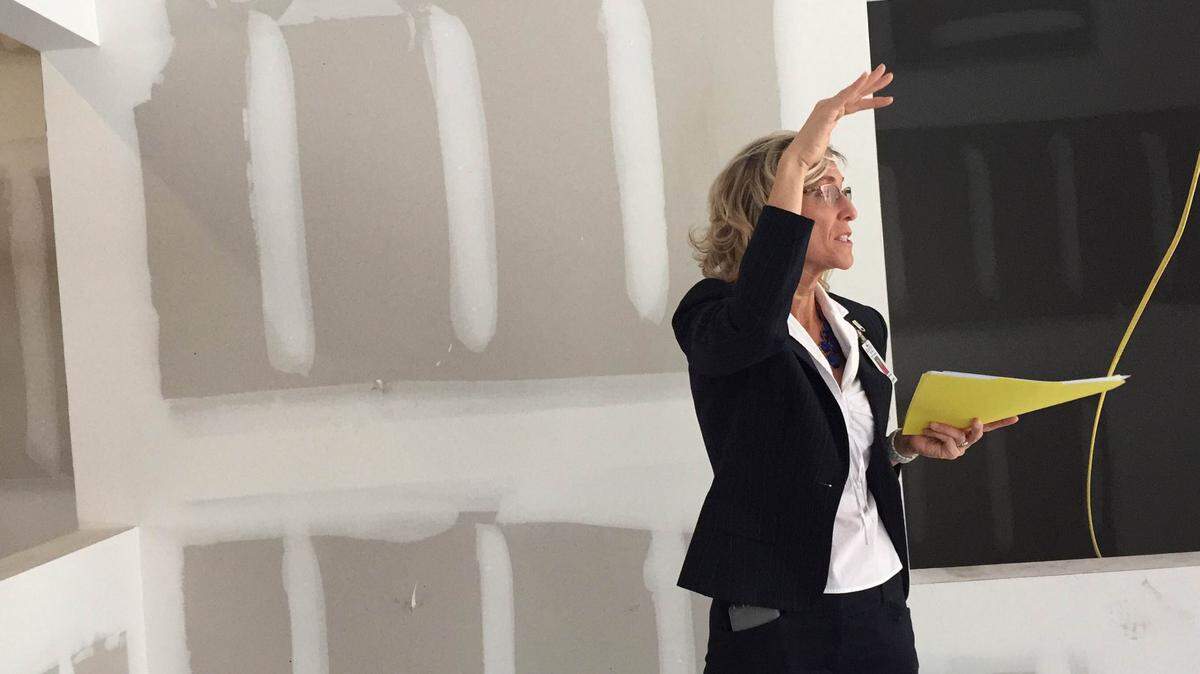 Heidi Sikkema, Bradenton Christian School's director of development, talks to visitors about how officials planned a low lobby ceiling -- instead of a grand foyer -- for the new middle-school building to maximize classroom space on the second floor.MEGHIN DELANEY/Bradenton Herald