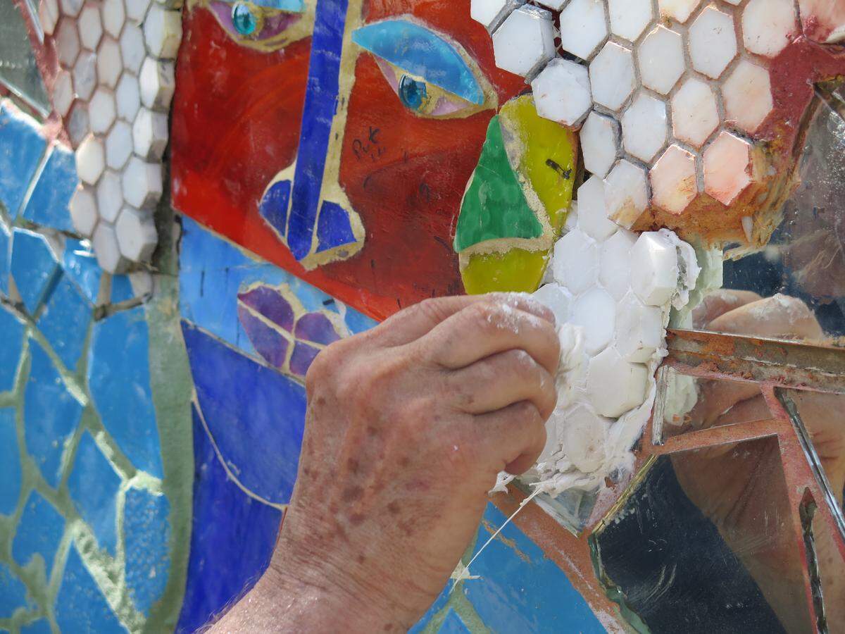 Pittsburgh-based artist James Simon adds a group of tiles to “The Magic River,” a mosaic mural decorating the north side of the City Centre parking garage in downtown Bradenton. Simon created the mural on 15 panels that were shipped to Bradenton and are being installed this week.