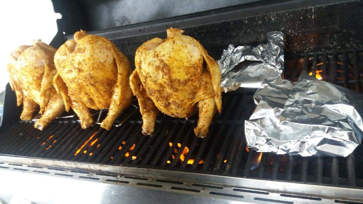 Lovina Eicher’s daughter Loretta and her friend Dustin prepared grilled whole chickens for the family on a recent Sunday.