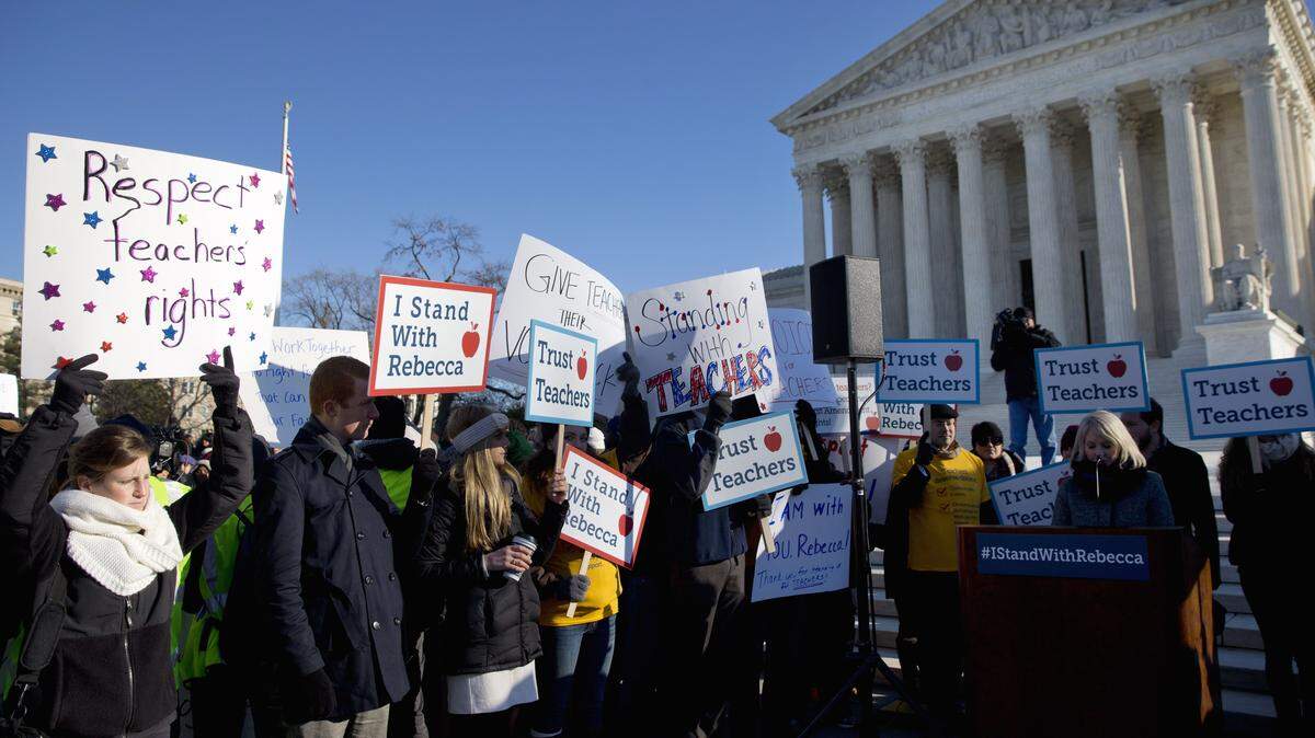 People participate in a rally at the Supreme Court in Washington, Monday, Jan. 11, 2016, as the court heard arguments in the 'Friedrichs v. California Teachers Association' case. The justices were to hear arguments in a case that challenges the right of public-employee unions to collect fees from teachers, firefighters and other state and local government workers who choose not to become members. (AP Photo/Jacquelyn Martin)