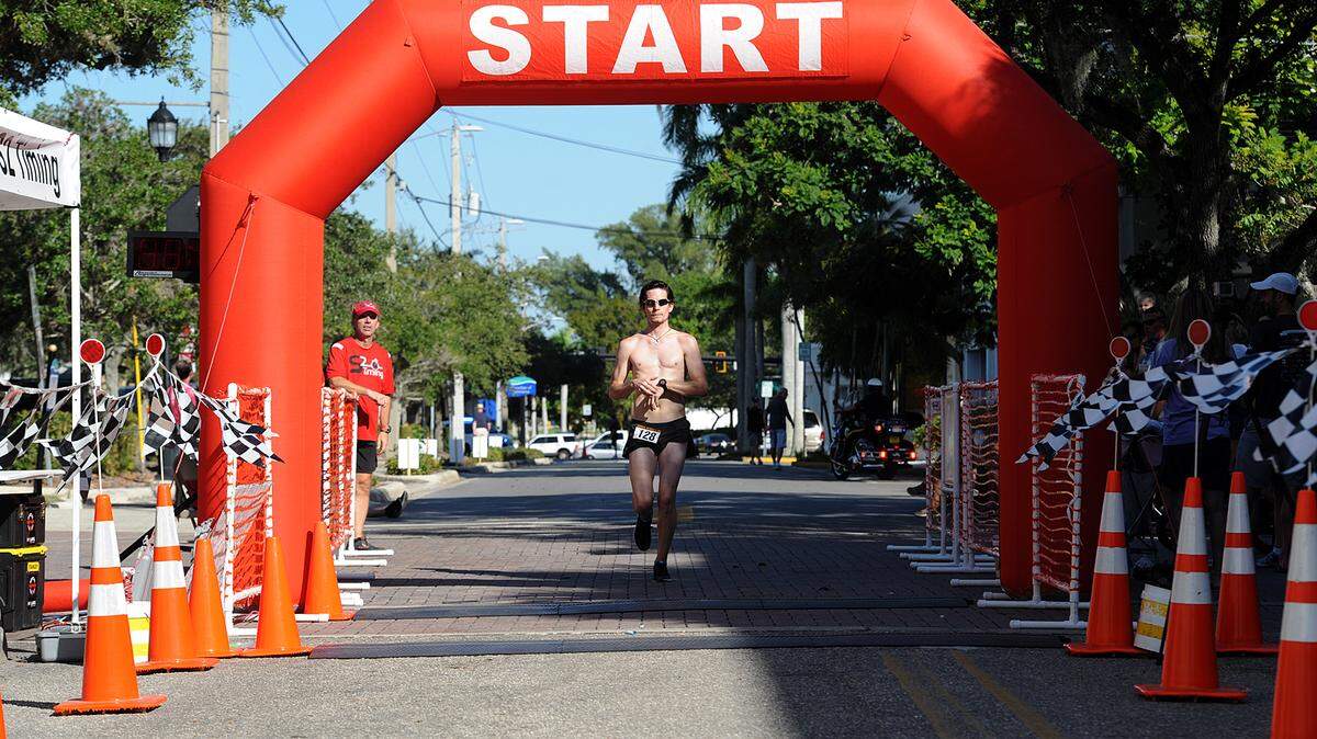Michael Lamb crosses the finish line in first place for the 5K Ghost Run Saturday on Bradenton's Old Main Street. The races were a benefit for the Robinson Hearts and Minds Foundation.TIFFANY TOMPKINS-CONDIE/Bradenton Herald
