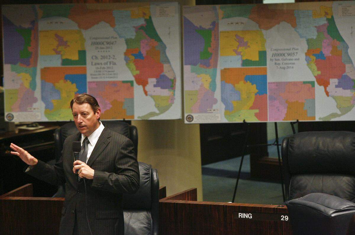 El presidente del Senado para la Reasignación de Distritos, el senador Bill Galvano, republicano por Bradenton, discute una enmienda en el pleno del Senado en agosto de 2014 en el Capitolio en Tallahassee. Detrás de él están los mapas de los distritos del Congreso de la Florida de 2012, a la izquierda, y los distritos modificados que propuso en el Proyecto de Ley del Senado 2.