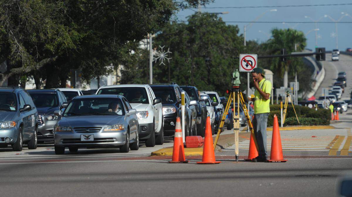 Craig Leks, with CivilSurv Design Group Inc. of Lankeland, surveys the intersection Tuesday of Manatee Avenue West and Ninth Street West in preparing for roadwork to ease traffic flowing into Bradenton from the Green Bridge. 
 GRANT JEFFERIES/Bradenton Herald