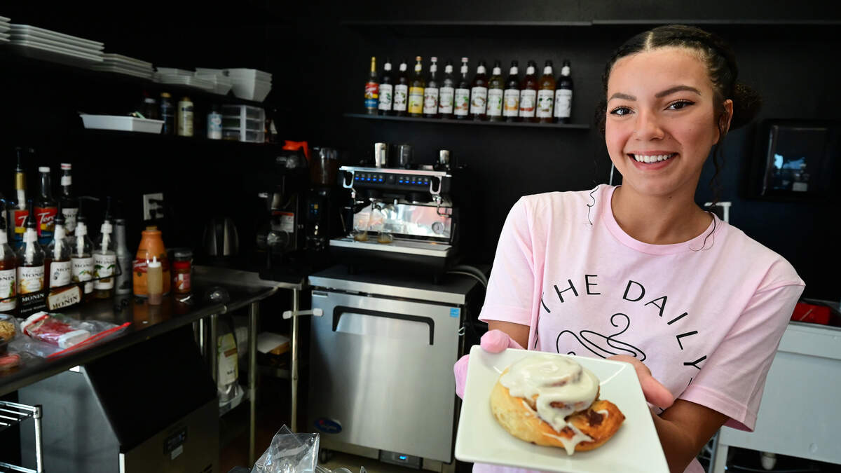 Co-owner Kaliya Taylor with a fresh cinnamon roll at The Daily Brew Station at 551 17th Street West in Palmetto shown on April 23, 2026.