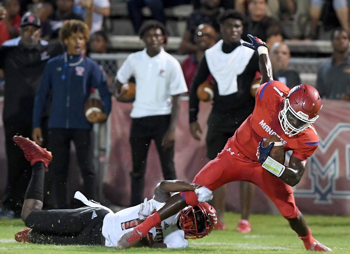 Manatee High’s Keyon Fordham is slowed by the Palmetto defense during Friday night’s victory over the Tigers.