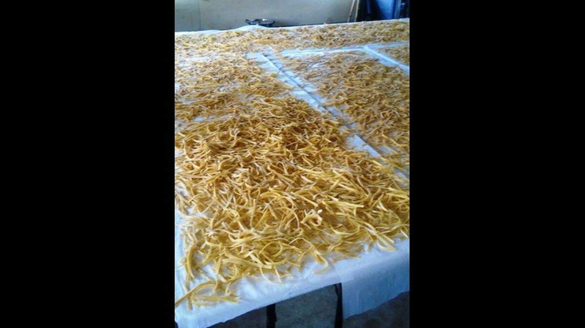 Along with her daughters and sisters, Lovina Eicher helped with noodle-making in preparation for her niece’s wedding. Before storing, the cut noodles are spread out on tables to dry. Noodles are often served at Amish weddings and church services.