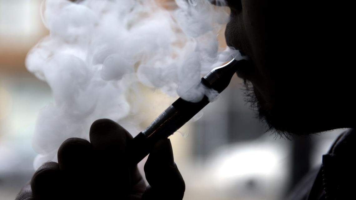 FILE - In this April 23, 2014, file photo, a man smokes an electronic cigarette in Chicago. On Thursday, May 5, 2016, the Food and Drug Administration released long-awaited rules that bring the burgeoning electronic cigarette industry under federal oversight. (AP Photo/Nam Y. Huh, File)