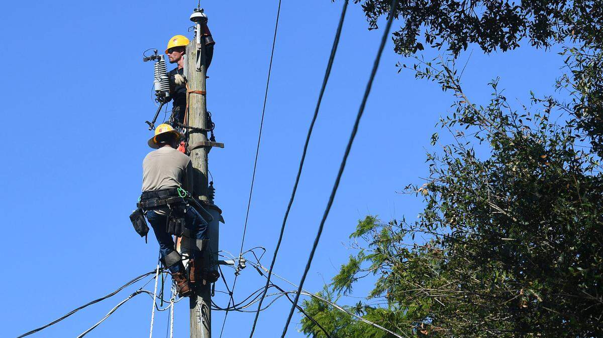 MasTec linemen work on power lines in West Bradenton on October 3, 2022 after Hurricane Ian left thousands in Manatee County without power. 